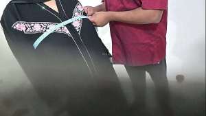 Tailor using hijab lady while taking measurement of blouse